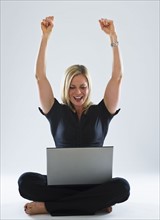 Young woman using laptop, celebrating. Photo : Daniel Grill