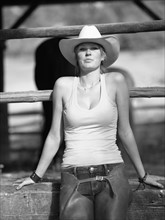 USA, Colorado, Portrait of cowgirl sitting by fence. Photo : John Kelly