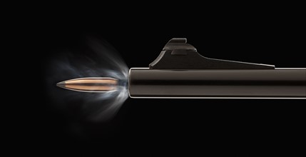 Studio shot of bullet coming out of gun barrel. Photo : Mike Kemp