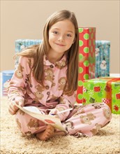 Portrait of girl (6-7) preparing Christmas presents. Photo : Mike Kemp