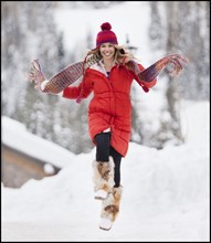 USA, Utah, Salt Lake City, Portrait of young woman skipping in snow. Photo : Mike Kemp