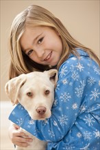Portrait of girl (10-11) embracing Labrador . Photo : Mike Kemp