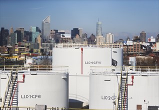 USA, New York City, Oil storage tanks in refinery with Manhattan skyline in background. Photo :