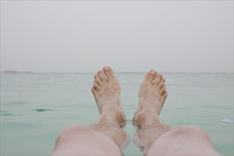 Israel, Dead Sea, mature men's legs in sea. Photo : Johannes Kroemer