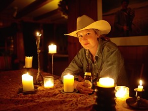 USA, Colorado, Portrait of cowgirl sitting at table with candles. Photo : John Kelly