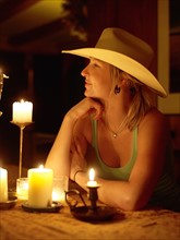 USA, Colorado, Cowgirl sitting at table with candles. Photo : John Kelly