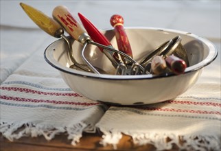 Antique cooking utensils in bowl.