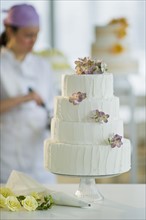 Wedding cake, pastry chief in background.