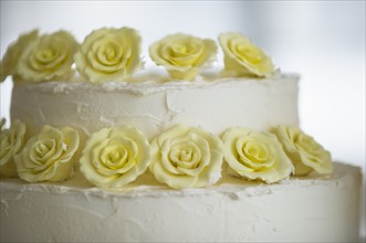 Close-up on wedding cake decorated with flowers.