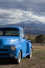 USA, Colorado, Carbondale, Blue vintage car, mount Sopris in background. Photo : Noah Clayton