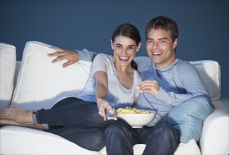 Couple sitting in front of television.
