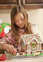 Portrait of girl (6-7) making gingerbread house. Photo : Mike Kemp