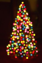 Defocused Christmas tree with colorful lights.