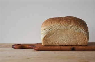 Close up of loaf of bread on cutting board.