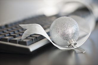 Close-up of silver bauble and computer keyboard.