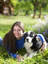 USA, Colorado, Portrait of young woman embracing dog on grass. Photo : John Kelly