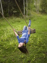 USA, Colorado, Young woman on swing in field. Photo : John Kelly