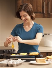 Woman preparing breakfast in kitchen. Photo : Mike Kemp