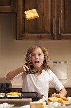 Girl (10-11) flipping toast in kitchen. Photo : Mike Kemp