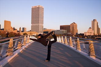 USA, Wisconsin, Milwaukee, Woman doing yoga on bridge in city. Photo : Henryk Sadura