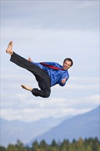 USA, Montana, Whitefish, businessman performing high kick mid-air. Photo : Noah Clayton