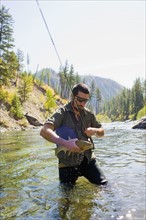 USA, Montana, Man fly fishing in North Fork of Blackfoot River. Photo : Noah Clayton