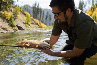 USA, Montana, Man holding fish in North Fork of Blackfoot River. Photo : Noah Clayton