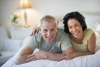 Happy mature couple laying in bed.