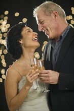 Mature couple toasting with champagne.