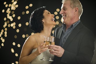 Mature couple toasting with champagne.