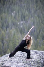 USA, Colorado, Aspen, woman stretching on rock. Photo : Noah Clayton