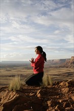 USA, Utah, Canyonlands National Park, woman meditating on rock. Photo : Noah Clayton