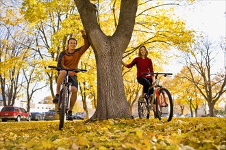 USA, Montana, Kalispell, Portrait of couple at bikes in park. Photo : Noah Clayton