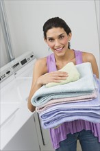 Woman holding stack of fresh towels.