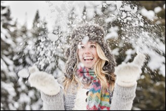 USA, Utah, Salt Lake City, young woman playing in snow. Photo : Mike Kemp