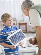 Grandson (8-9) showing solar panel to Grandfather. Photo : Jamie Grill Photography