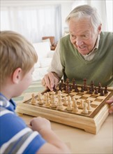 Grandfather and grandson (8-9) playing chess. Photo : Jamie Grill Photography