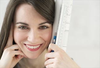 Close-up of woman holding ruler and pencil.