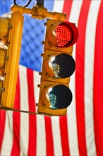 Traffic lights with american flag in background.