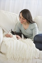 Woman with cat on sofa.