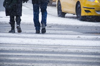 USA, New York City, Pedestrians crossing road in blizzard.