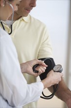 Doctor checking patient's blood pressure.