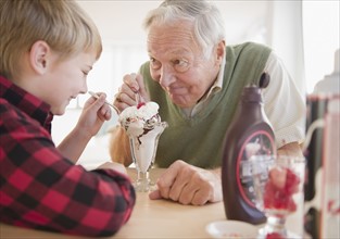 Grandfather and grandson (8-9) eating ice cream. Photo : Jamie Grill Photography