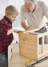 Grandfather and grandson (8-9) improving wooden stool. Photo : Jamie Grill Photography