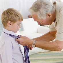 Grandfather tying grandson's (8-9) tie. Photo : Jamie Grill Photography