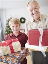Grandfather and grandson (8-9 years) holding christmas gifts. Photo : Jamie Grill Photography
