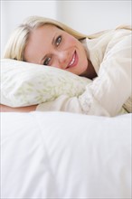 Portrait of woman lying on bed. Photo : Daniel Grill