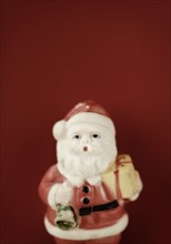 Father christmas figurine on red background.