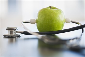 Green apple with stethoscope.
