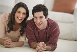 Portrait of couple lying on floor.